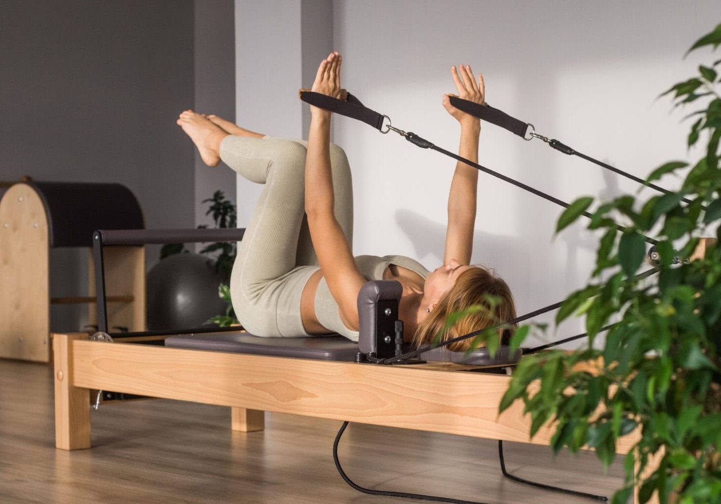 Client practising Reformer Pilates in a calm studio at Axis Pilates Studio in Leatherhead